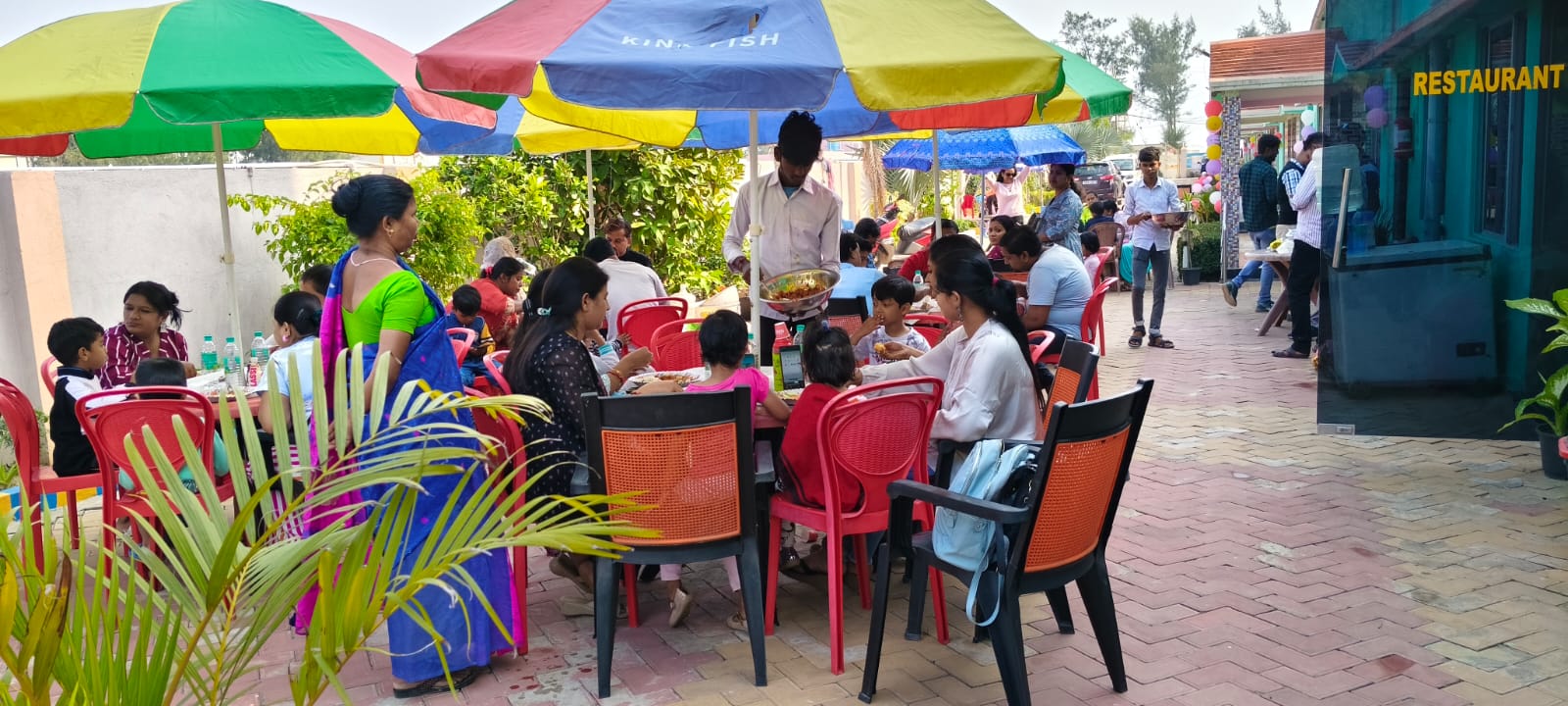 Outdoor Garden Lawn Dining Under Colorful Umbrellas at Samriddha Beach Resort